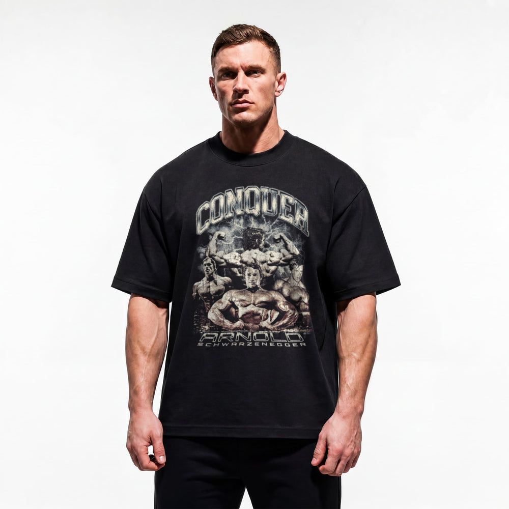 Model wearing Most Natty Conquer bodybuilding oversized t-shirt showing relaxed drop-shoulder fit