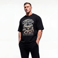 Model wearing Most Natty Conquer bodybuilding oversized t-shirt showing front graphic print