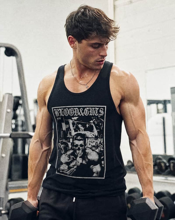 Man in gym holding dumbbells wearing Blood & Guts Tank Top