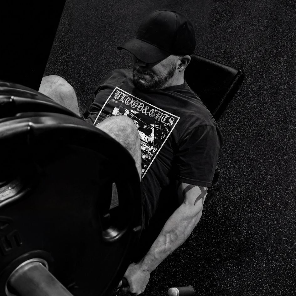Man wearing Blood and Guts t-shirt design lifting heavy weights in a gym setting