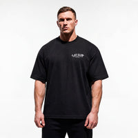 Model wearing Most Natty LAT Club bodybuilding oversized t-shirt showing relaxed drop-shoulder fit