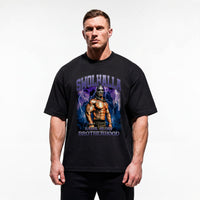 Model wearing Most Natty Swolhalla bodybuilding oversized t-shirt featuring Rich Piana, showing relaxed drop-shoulder fit