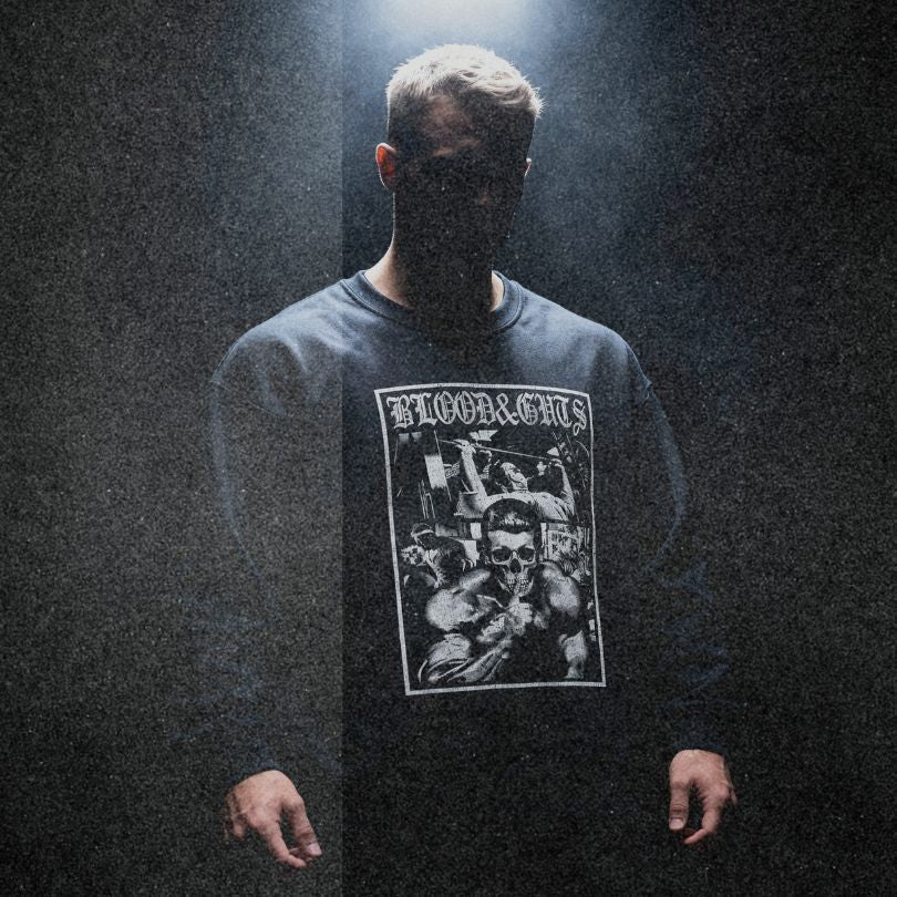 Model wearing Dorian Yates Blood and Guts bodybuilding pump cover crewneck showing relaxed oversized fit in moody setting