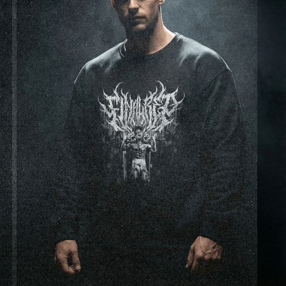 Model wearing Tom Platz Final Rep bodybuilding pump cover crewneck in dark moody gym setting with dramatic lighting
