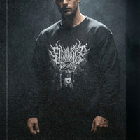 Model wearing Tom Platz Final Rep bodybuilding pump cover crewneck in dark moody gym setting with dramatic lighting