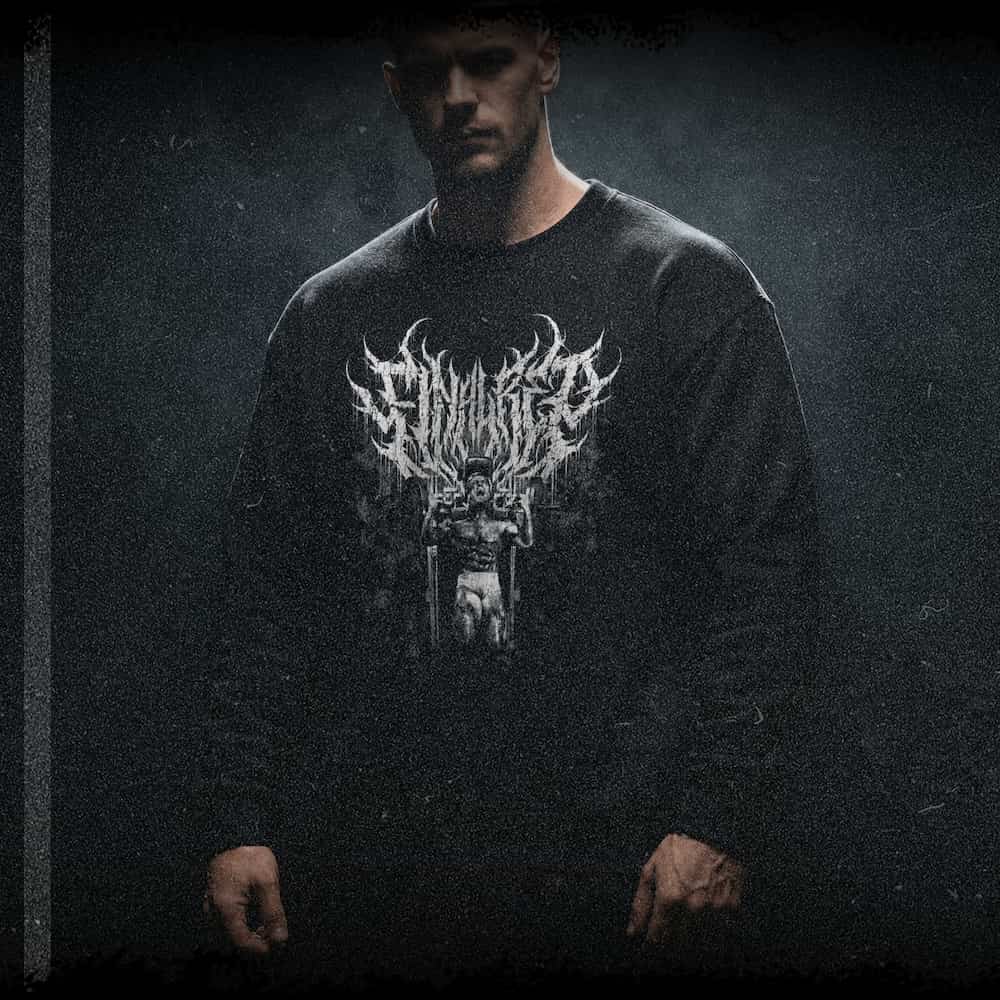 Man wearing the Final Rep dark sweater, a Tom Platz tribute graphic with a moody side-lit look