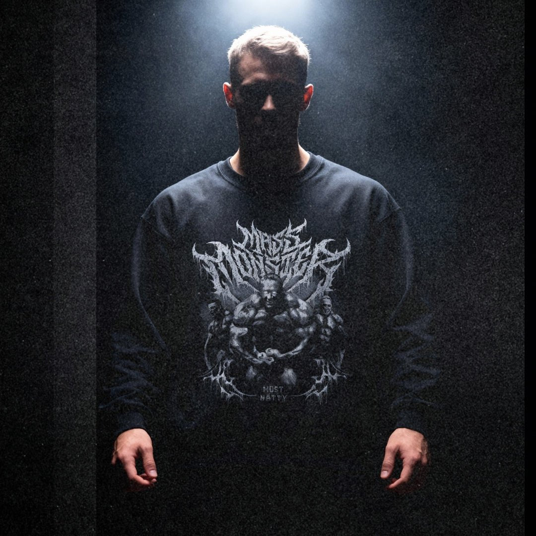 Model wearing Markus Ruhl Mass Monster bodybuilding pump cover crewneck in dark moody gym setting with dramatic lighting